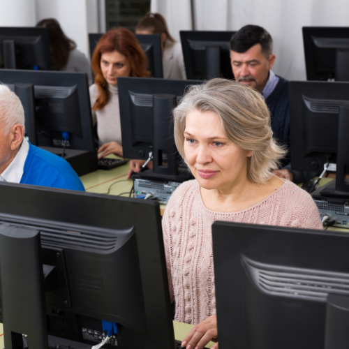 Older adults focused on learning in a computer lab setting.