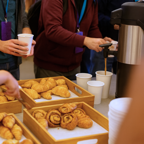 People serving themselves coffee and pastries from a buffet table.