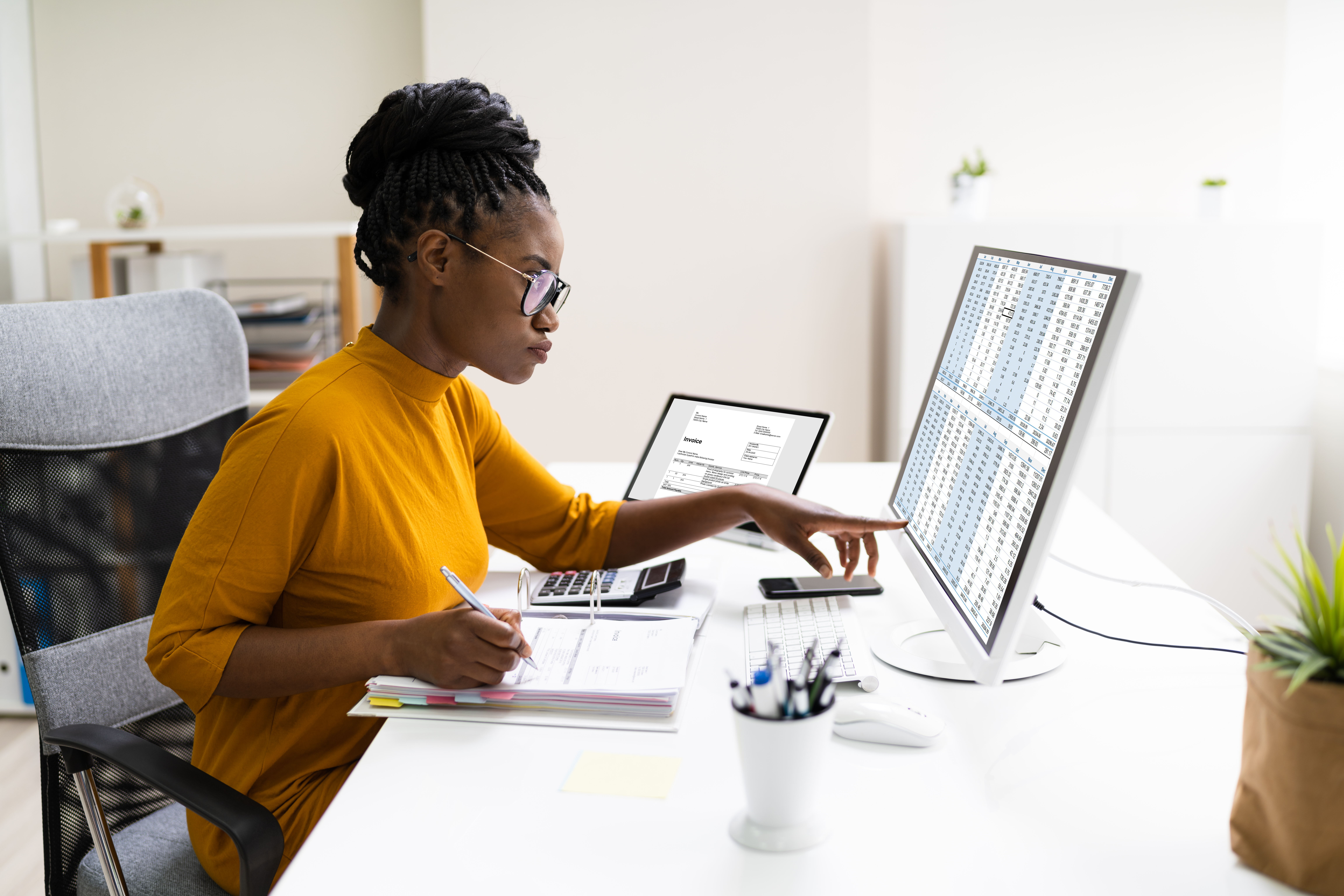 Woman working at a desk in a modern office setting.