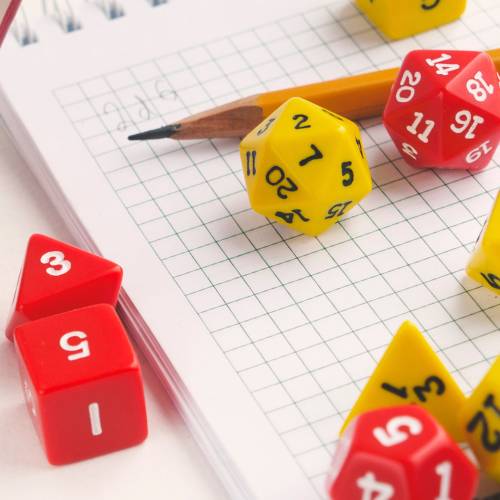 Colorful dice and a pencil on graph paper for tabletop roleplaying games.